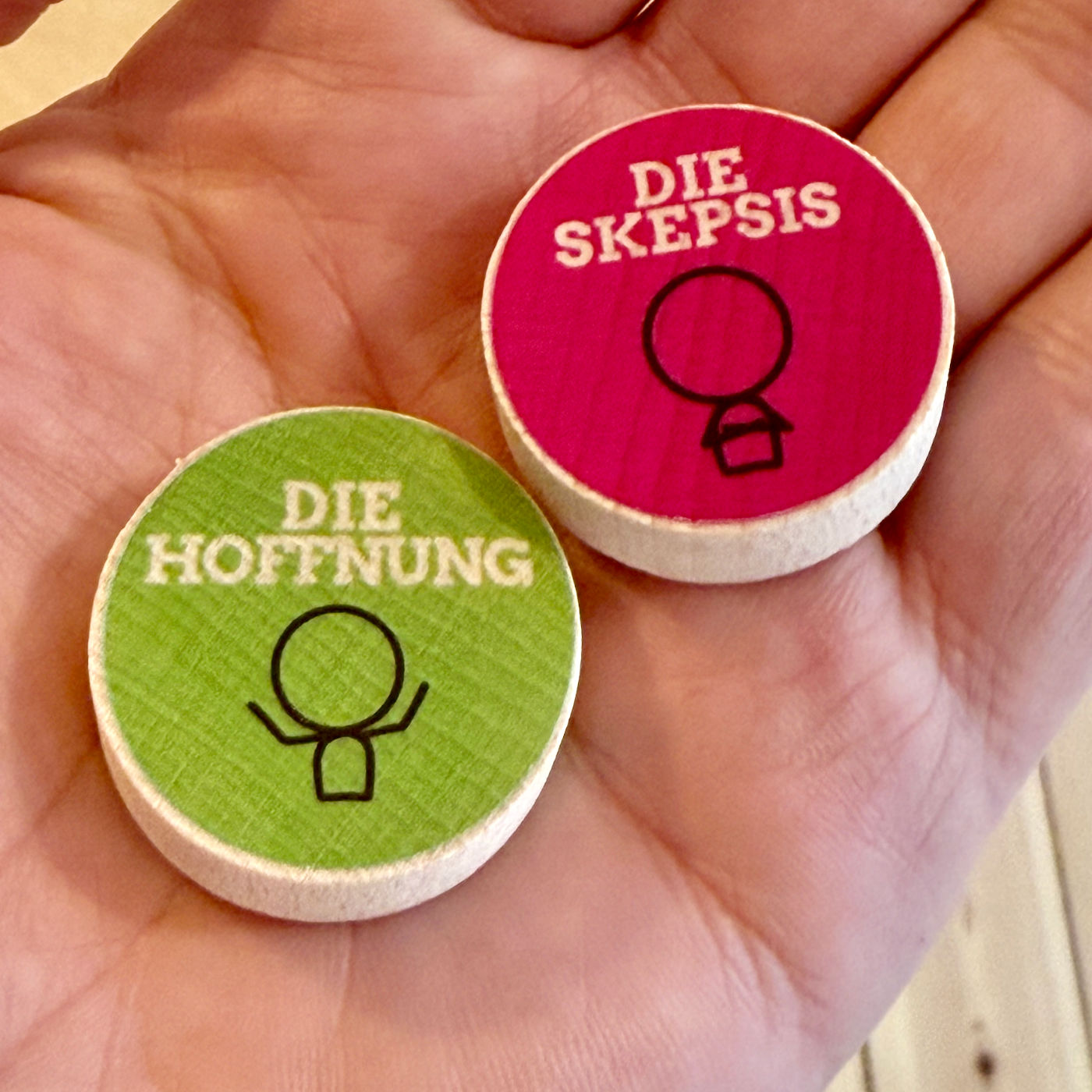 Detail-Aufnahme der Coaching-Holzsteine in einer Hand: Die Hoffnung und die Skepsis