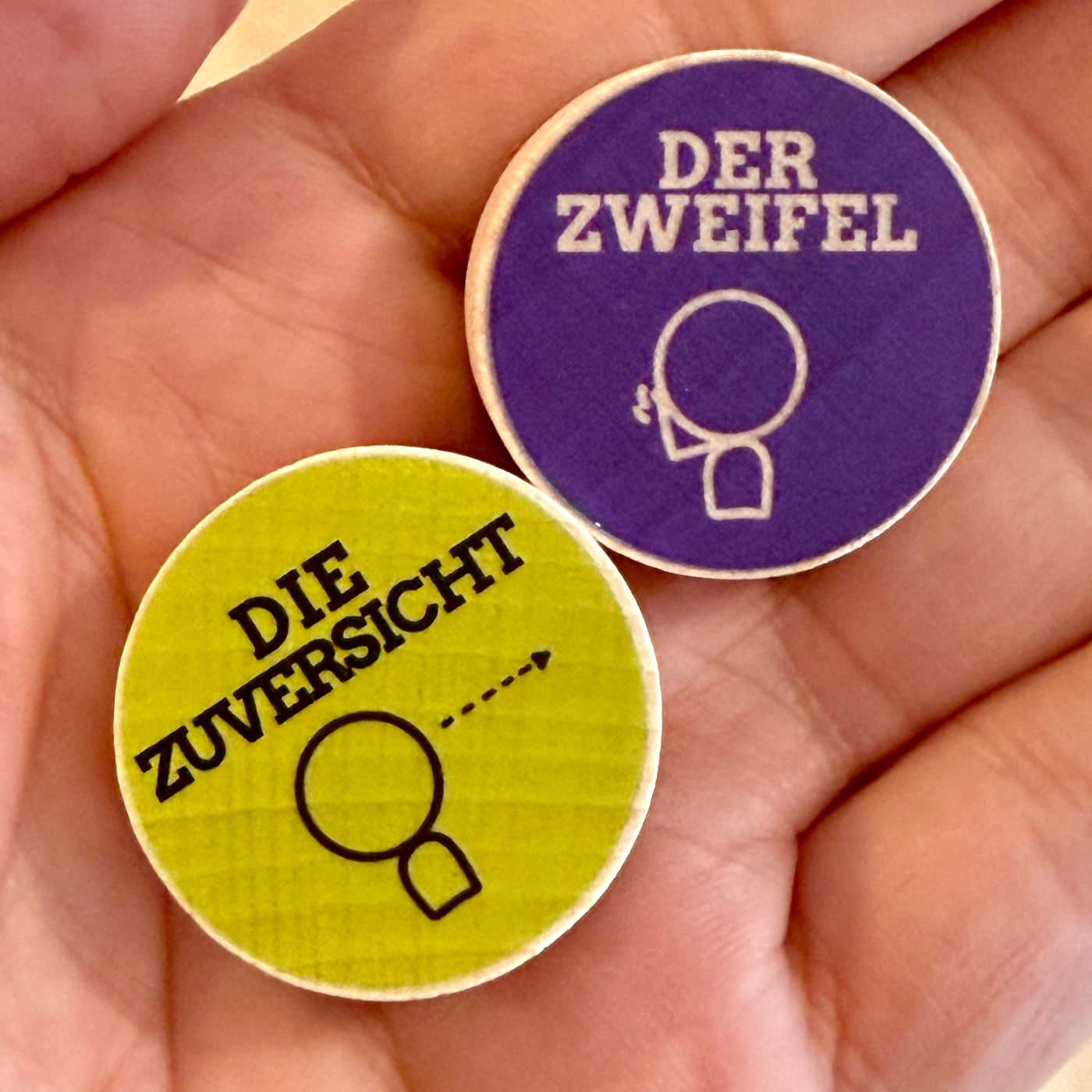 „Zuversicht“ und „Zweifel“ als Holzsteine für Coaching und Supervision auf der Handfläche